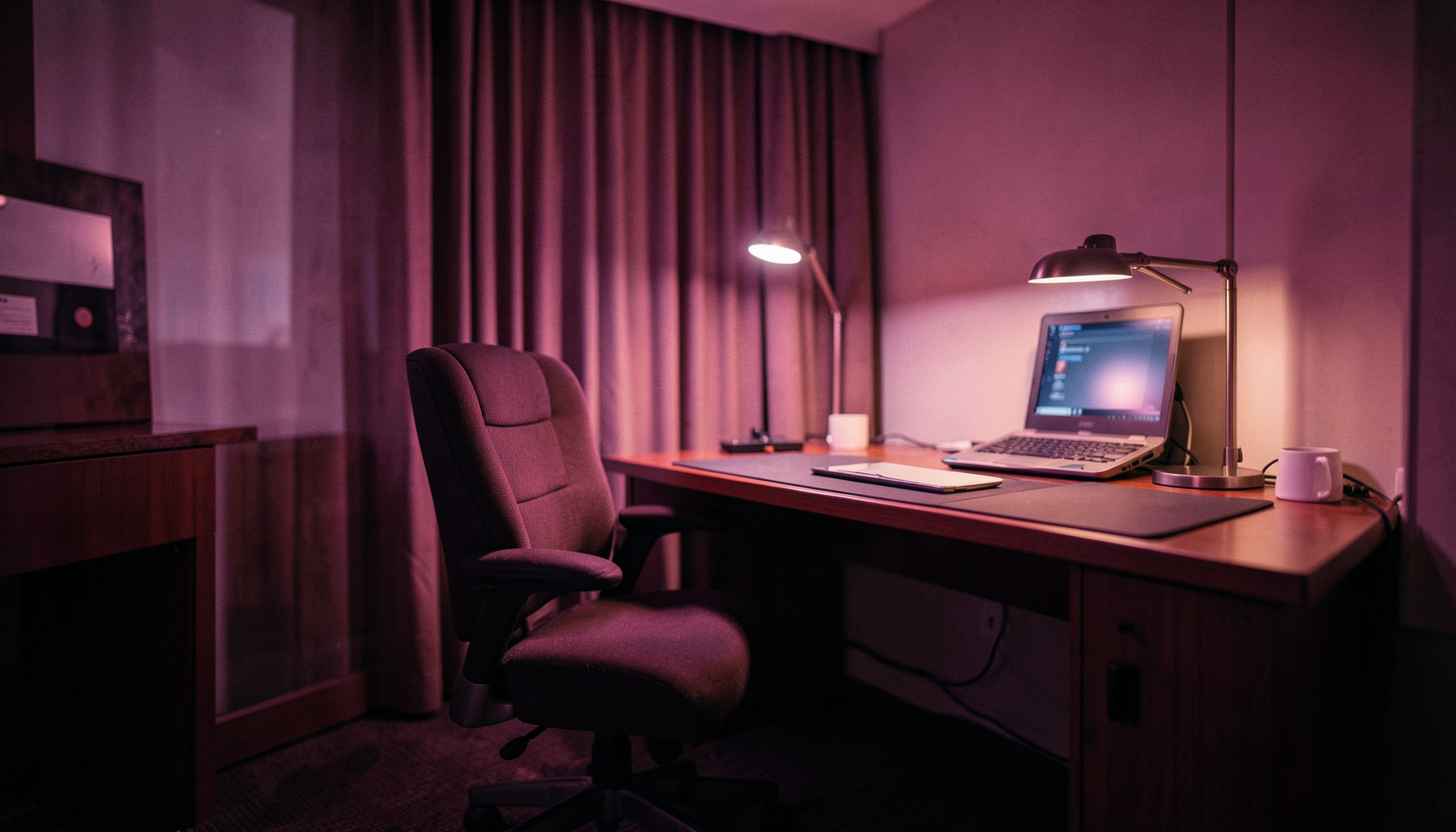 Bureau ergonomique dans une chambre d'hôtel avec chaise design et lampe de travail